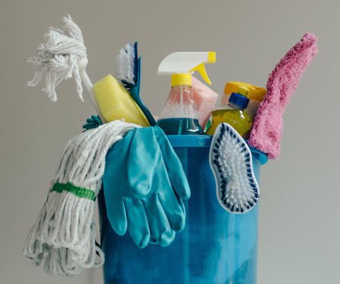 Professional house cleaning supplies in a blue bucket